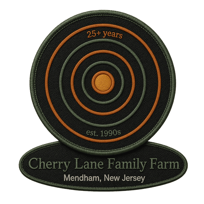 A two-piece embroidered patch concept: the rings mark on a round patch above an oval nameplate patch reading Cherry Lane Family Farm, Mendham, New Jersey, dark thread on canvas